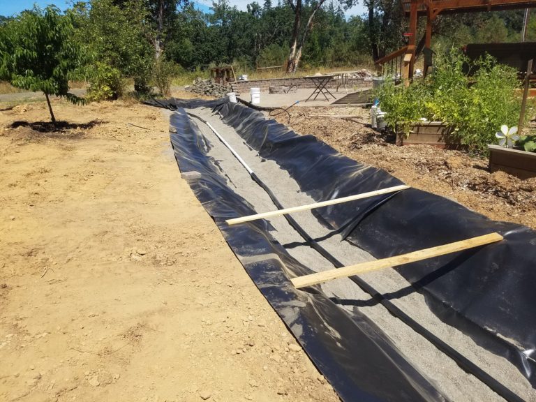 A small amount of sand and some boards held the liner in place while the flexible return pipe was laid. Looking up toward spring.