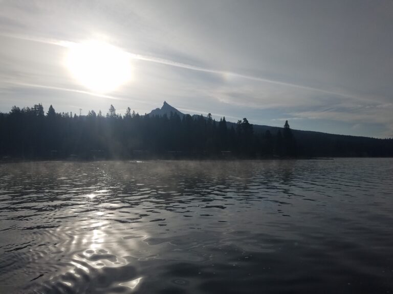 Rising sun over Mt. Thielsen and smooth morning waters of Diamond Lake.